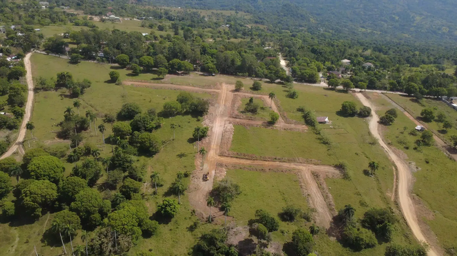 Vista aérea real del avance del terreno y las vías internas del proyecto junto a la montaña.
